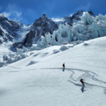 Aerial view of two skiiers going down the piste in the Alps.